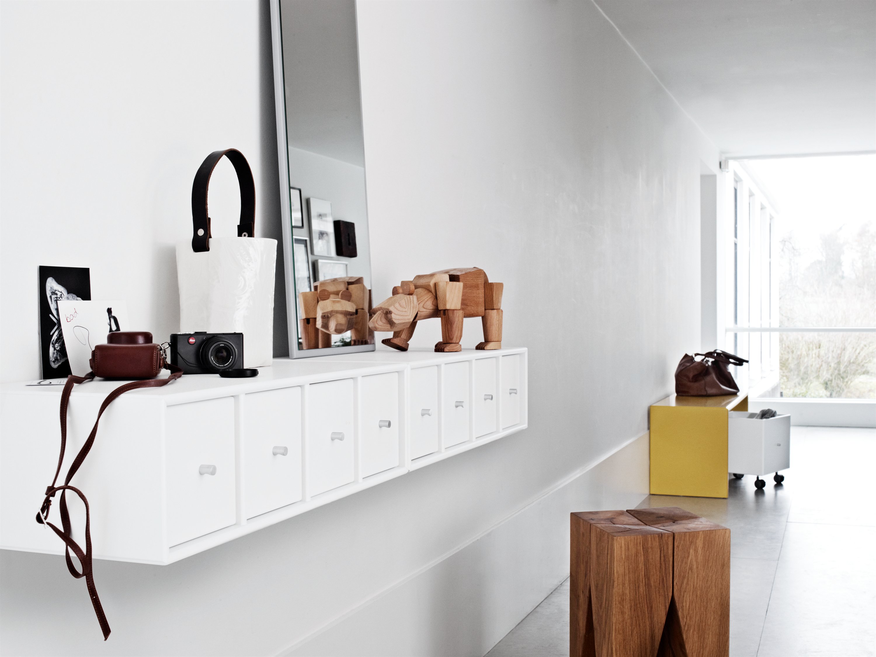 En lang smal veggmontert hylle med skuffer er både dekorativt samtidig som det gir oppbevaringsplass. Montana gang møbel